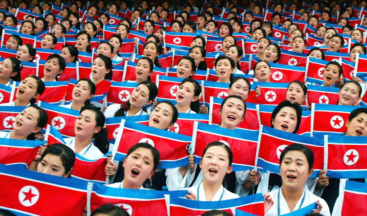 Észak-koreai táncosok és zenészek észak-koreai zászlókat lengetnek a 22. Nyári Universiade Játékok megnyitó ünnepségén 2003. augusztus 21-én a dél-koreai Daeguban.