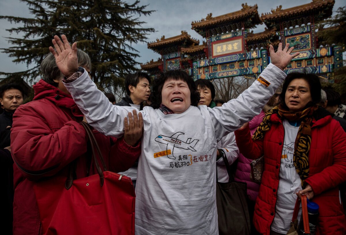 Peking, Kína - Március 08.: A Malaysia Airlines MH370-es járatának eltűnt utasának kínai rokona sír a Lama templom főkapuja előtt 2015. március 8-án Pekingben, Kínában. A kínai rendőrség megakadályozta, hogy a külföldi és helyi média tudósítson a rokonok látogatásáról a templomban, ahol imádkozni próbáltak. 239 ember volt a járat fedélzetén, amikor az 2014. március 8-án eltűnt Kuala Lumpurból Pekingbe tartó útvonalon. Egy év és kimerítő keresés után a nyomozóknak még mindig nincs nyomuk az eltűnt repülőgép hollétéről. (Fotó: Kevin Frayer/Getty Images)