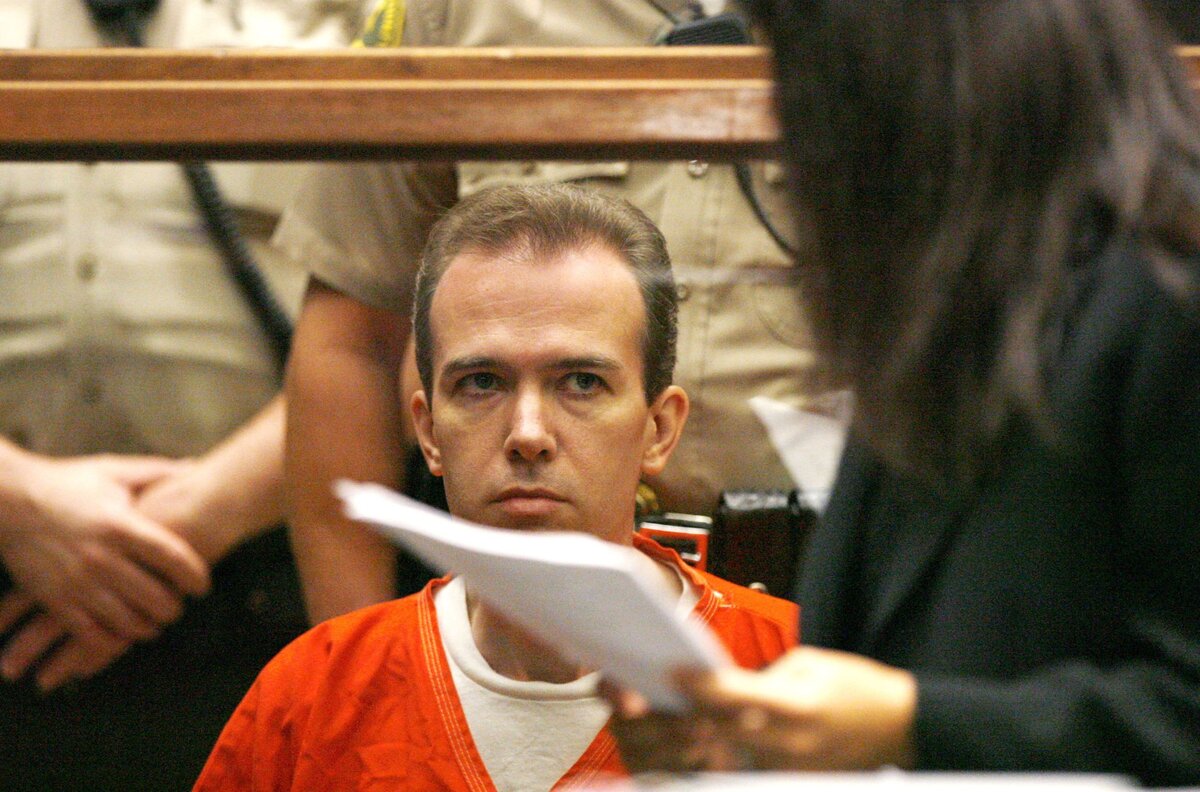 John Mark Karr, a gyermek szépségkirálynő, JonBenet Ramsey meggyilkolásának gyanúsítottja a Los Angeles-i Legfelsőbb Bíróságon tartott kiadatási meghallgatáson nézi Haydeh Takasugi helyettes kirendelt kirendelt védőt 2006. augusztus 22-én Los Angelesben, Kaliforniában. Karr beleegyezett abba, hogy kiadják Colorado államnak, hogy szembenézzen a JonBenet Ramsey-ügyben elkövetett gyilkosság, emberrablás és szexuális erőszak vádjával.