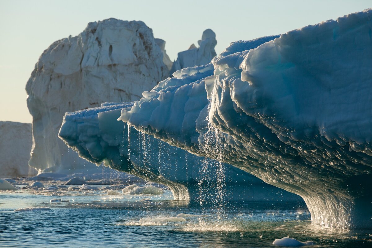 A Jakobshavn-gleccser hatalmas jéghegyei olvadnak a Disko-öbölben egy napsütéses nyári estén, Ilulissat, Grönland.