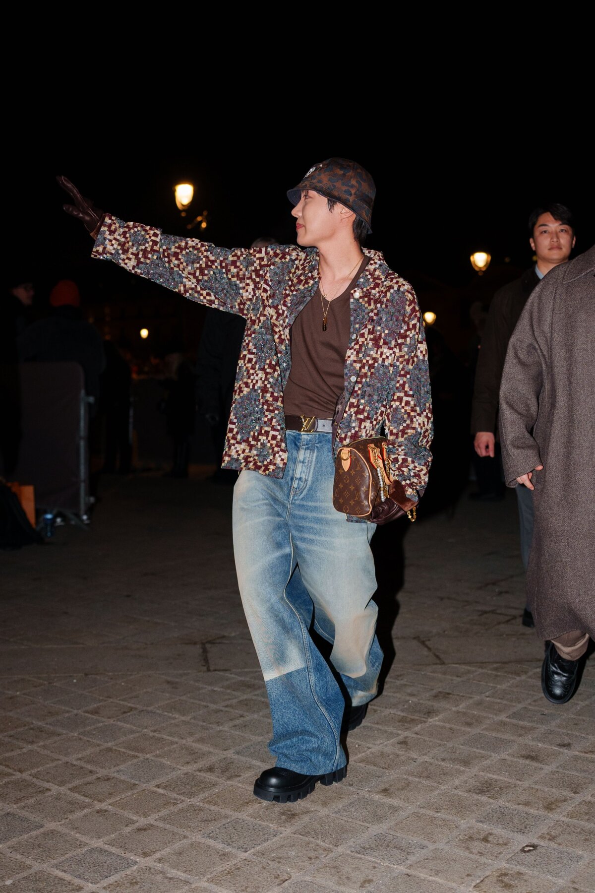 J-Hope bob sapkát, színes kockás mintás oversize blézer kabátot , barna pólót, barna bőr monogramos Louis Vuitton táskát, széles szárú farmer nadrágot / farmert, fekete bőrcipőt visel a Louis Vuitton Menswear Fall-Winter 2025/2026 show előtt a Párizsi Divathét keretében 2025. január 21-én, Párizsban, Franciaországban. (Fotó: )