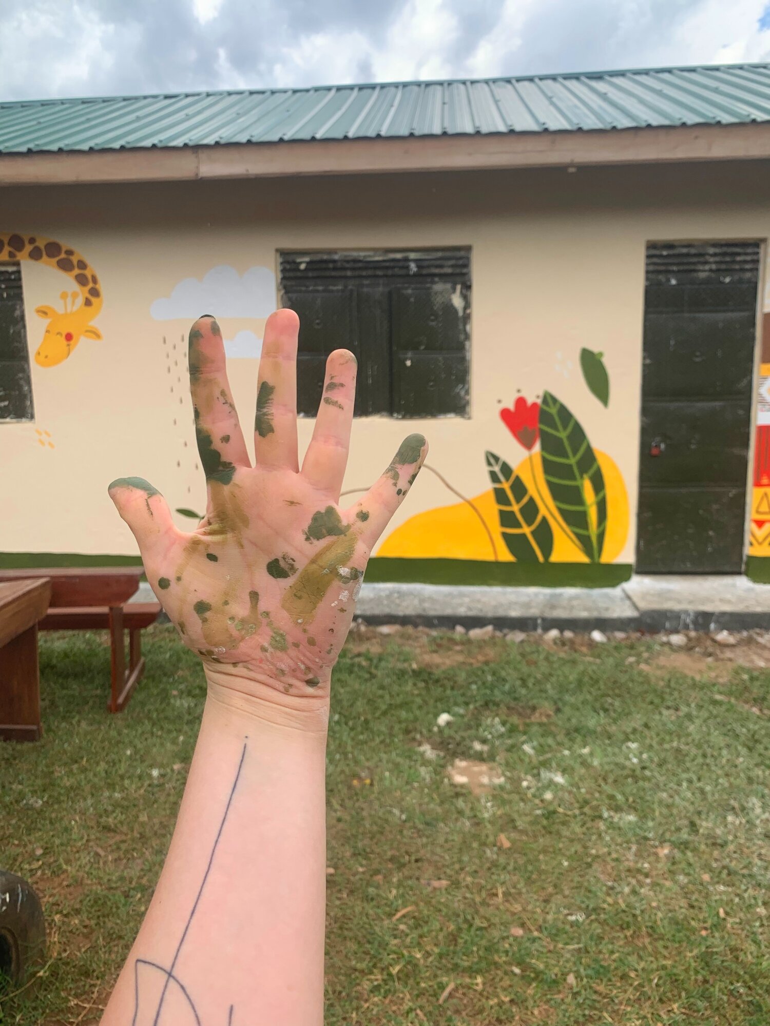A dzsungel közepén, a manafwai iskola a művészlány keze vonásait viseli magán.